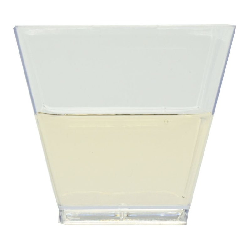 May include: A clear plastic square dish filled with a light yellow liquid.