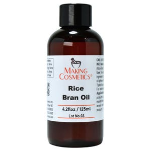 May include: A brown glass bottle of Rice Bran Oil with a black cap. The label reads "MAKING COSMETICS" and "Rice Bran Oil 4.2 fl oz / 125ml". The bottle is filled with a clear, amber-colored liquid.
