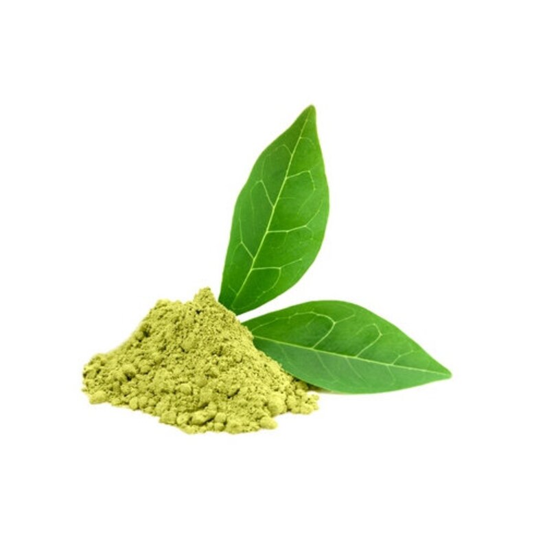 May include: A pile of fine, light green powder with two vibrant green leaves. The powder is textured and appears to be a natural product. The leaves have prominent veins and are positioned behind the powder.