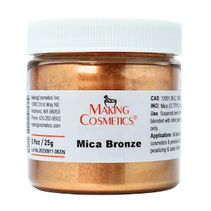 May include: A jar of Mica Bronze cosmetic powder from Making Cosmetics. The jar has a white lid and a label with the brand name and product information. The jar contains 0.9 oz / 25g of bronze-colored powder.