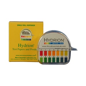 May include: A single roll dispenser of Hydrion pH test papers in a yellow box. The box has the company's website and contact information. The dispenser is clear plastic and has a color chart for pH levels from 0.0 to 13.0.