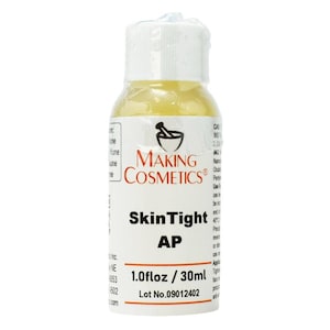 May include: A small, clear bottle of SkinTight AP from Making Cosmetics. The bottle has a white cap and a label with black and red text, including the product name and volume of 1.0 fl oz / 30ml. The liquid inside is yellow.