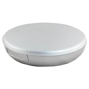 May include: A silver round compact with a smooth, shiny surface. The compact has a hinged lid and a slightly raised edge.