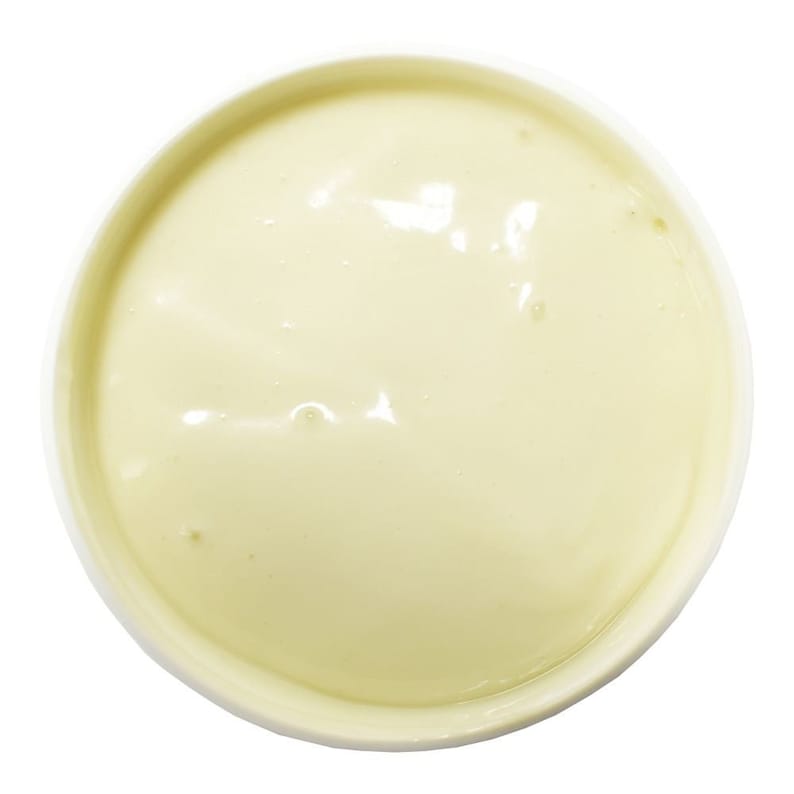 May include: Overhead view of a white bowl filled with a smooth, pale yellow substance. The substance has a glossy appearance with subtle variations in color and texture, suggesting a creamy consistency. The bowl is set against a clean white background.