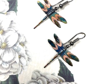 Könnte beinhalten: Ein Paar Libellenohrringe mit blauen, grünen und kupferfarbenen Akzenten. Die Ohrringe sind aus Metall und haben einen Hakenverschluss.
