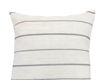 May include: Square decorative pillow with a white background and horizontal black stripes. The pillow has a textured appearance and a simple, modern design, suitable for home decor.