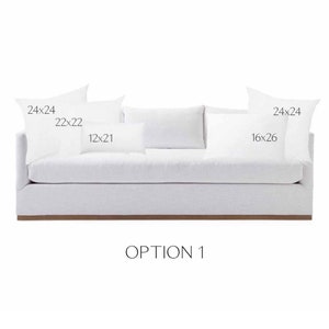 May include: A white sofa with four white throw pillows. The pillows are labeled with their dimensions: 24x24 inches, 22x22 inches, 12x21 inches, and 16x26 inches. The text "OPTION 1" is printed below the sofa.