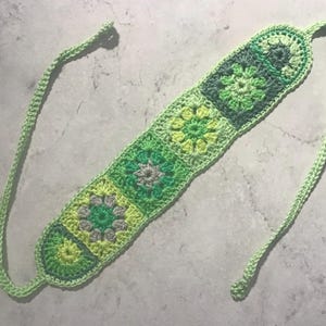 Crochet headband with granny squares in vibrant green and a little bit grey.