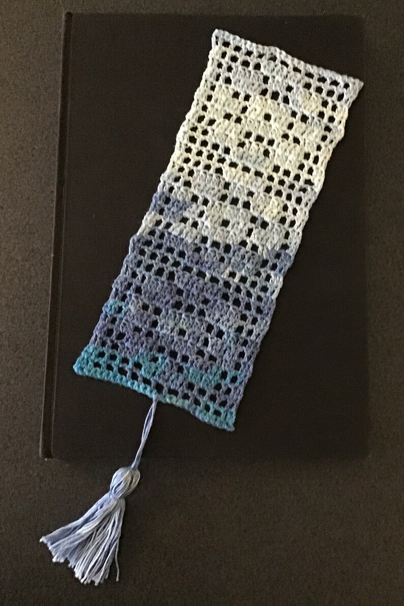 In filet crochet bookmark with flowers.