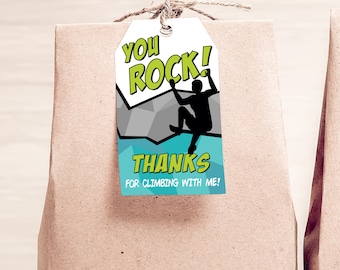May include: A white gift tag with a blue and gray rock climbing themed design. The tag says "You Rock!" in green letters and "Thanks for climbing with me!" in black letters.