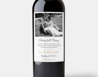 May include: A black wine bottle with a white label featuring a black and white photo of a couple. The label reads "Cheers to 40 Years" and "Happy Anniversary" with the names "Hayley and Steven".