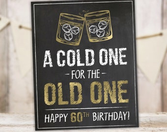 Può includere: Un cartello nero in ardesia con lettere dorate che recita "A Cold One - For The - Old One Happy 60th Birthday!"  Il cartello presenta due bicchieri dorati con cubetti di ghiaccio, e il testo "16X20" | "11X14" | "8X10" INSTANT DOWNLOAD SIGNS TANGLEDTULIP.ETSY.COM" in basso.