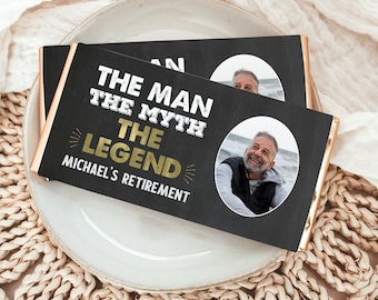 May include: A black and white chocolate bar wrapper with a photo of a man smiling. The text on the wrapper reads "The Man The Myth The Legend Michael's Retirement".