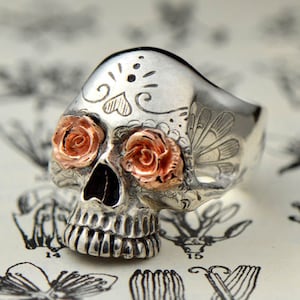 Silver sugar skull ring with red rosé gold roses as eyes for Day of the Dead aka Día de Muertos. Handmade sugar skull. Mexican skull ring.