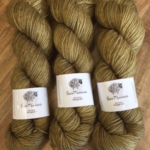 May include: Three skeins of olive green yarn with the label "Ewe Momma" on each skein.