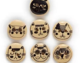 Puede incluir: Conjunto de ocho botones de madera con diferentes caras de gato. Los botones son beige con caras de gato negras y tienen un agujero en el centro para coser.