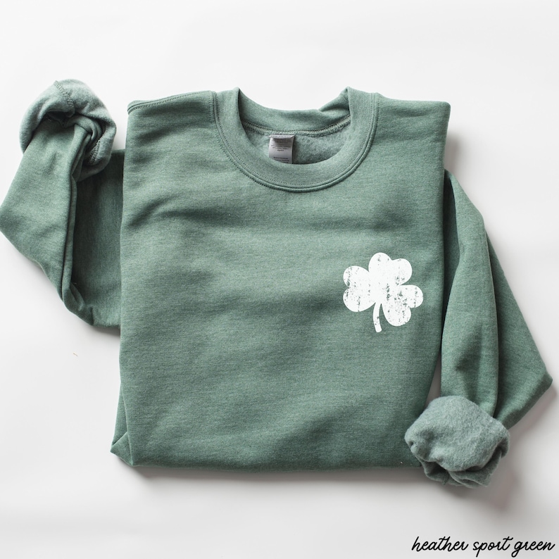 May include: A heather sport green sweatshirt with a white distressed shamrock design.