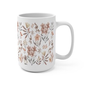 May include: White ceramic mug with a floral pattern in shades of brown and pink. The mug features a repeating design of various flowers and leaves.