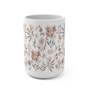 May include: White ceramic mug with a floral pattern in shades of brown and pink. The pattern features various flowers, leaves, and stems.