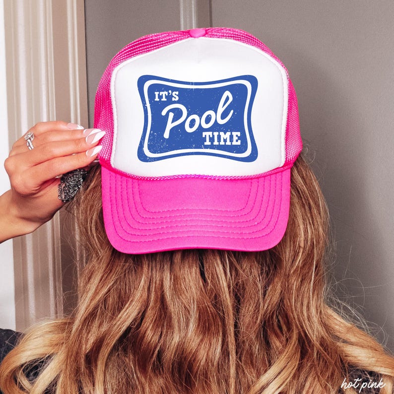 Może przedstawiać: R&oacute;żowa czapka typu trucker z białym panelem przednim z napisem "IT'S Pool TIME" w niebieskiej, postarzanej czcionce. Czapka ma siatkowy tył i zakrzywiony daszek, idealna na słoneczne dni.