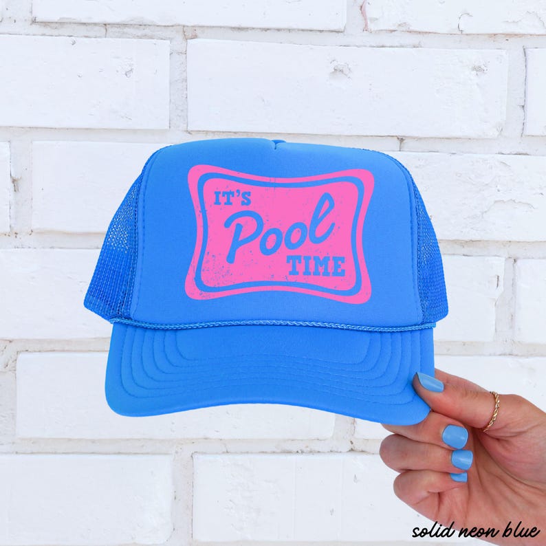 Może przedstawiać: Jasnoniebieska czapka typu trucker z r&oacute;żową prostokątną grafiką z napisem "IT'S Pool TIME". Czapka ma siatkowy tył i zakrzywiony daszek. Tekst "solid neon blue" znajduje się w prawym dolnym rogu.