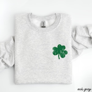 May include: Ash grey sweatshirt with a green shamrock graphic.