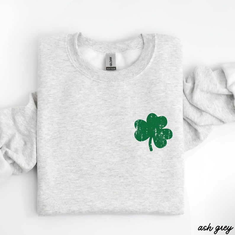 May include: Ash grey sweatshirt with a green shamrock graphic.