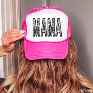 May include: A pink and white trucker hat with a black and white leopard print "MAMA" design.