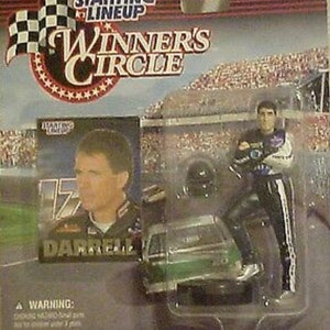 May include: A collectible die-cast toy car featuring a green and white race car with a driver wearing a black and white racing suit. The car is part of a Winner's Circle series and features the name "Darrell Waltrip" on the side.