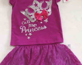 Puede incluir: Un conjunto de dos piezas para niñas, que incluye una camiseta morada con una corona plateada y el texto "Call me Princess" y una falda de tul morada a juego con estampado de leopardo.
