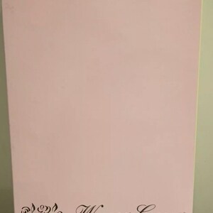May include: A pink Barbie doll box with the words "Winner's Circle" and "Barbie Doll" printed on it. The box has a floral design in black ink on the lower left corner. A light blue stripe is at the top.