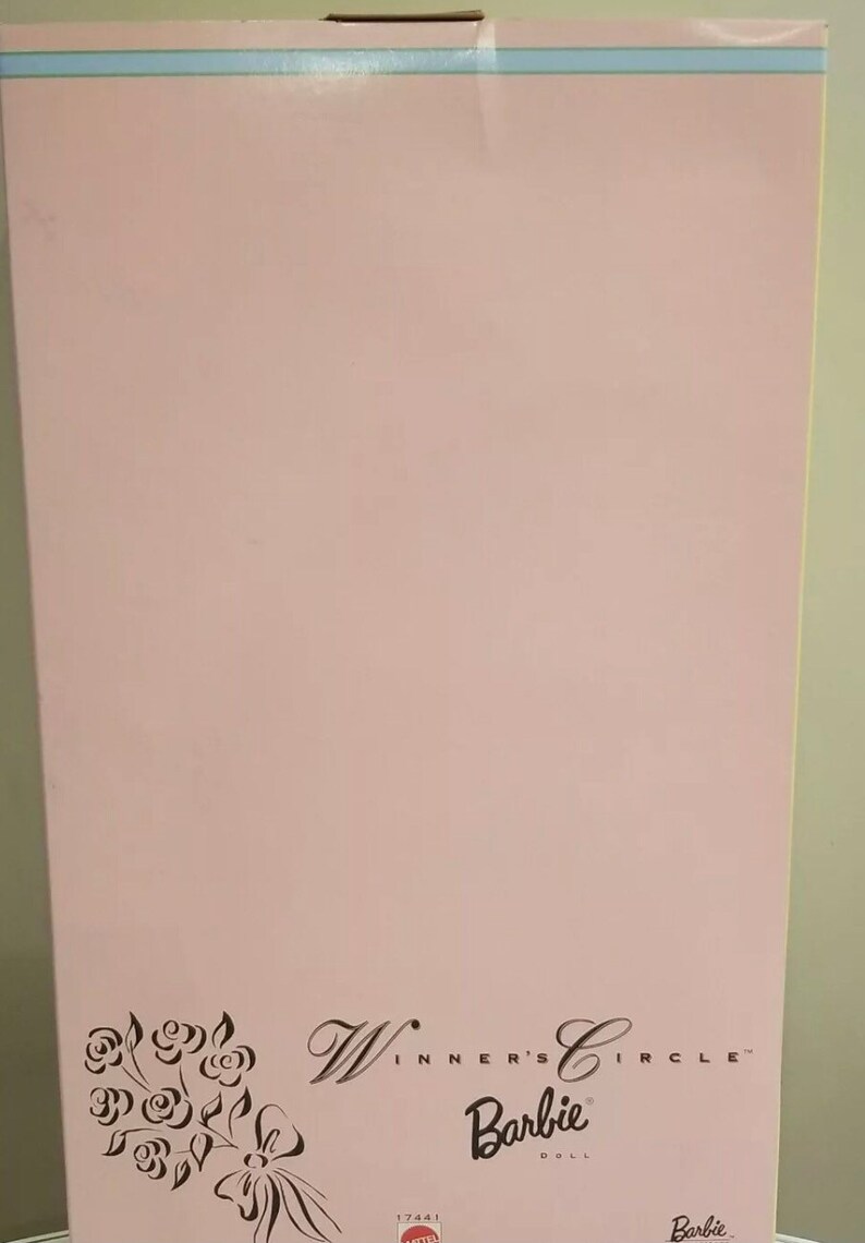 May include: A pink Barbie doll box with the words "Winner's Circle" and "Barbie Doll" printed on it. The box has a floral design in black ink on the lower left corner. A light blue stripe is at the top.