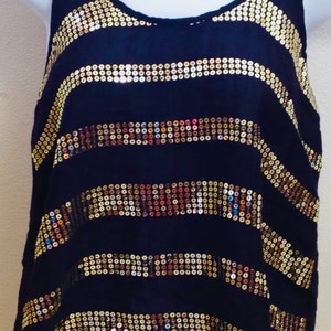 May include: A black sleeveless top with horizontal stripes of gold sequins. The sequins are arranged in a wavy pattern.
