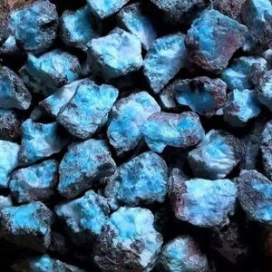 Puede incluir: Un conjunto de piedras naturales en bruto con un llamativo tono azul, que recuerda al océano. Las piedras tienen una superficie texturizada y diferentes tonos de azul, con algunos toques de marrón y gris. La imagen muestra una variedad de formas y tamaños.