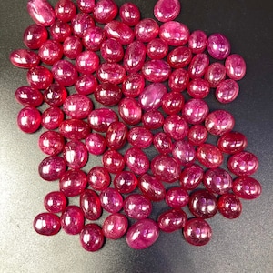 以下が含まれることがあります： 緩い、楕円形の赤い宝石のコレクション。宝石は滑らかで磨かれています