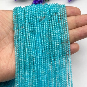 May include: A strand of light blue gemstone beads, approximately 2mm in diameter, strung on a thin wire. The beads are faceted and have a slightly irregular shape. The strand is approximately 18 inches long.