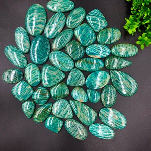 May include: A collection of 30 smooth, polished green amazonite stones with a striated pattern. The stones are oval and teardrop shaped.