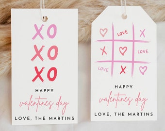 May include: Two Valentine's Day gift tags with pink and red accents. The first tag features the text "XO" repeated three times. The second tag features a tic-tac-toe board with hearts and "X" symbols. Both tags include the text "Happy Valentine's Day" and "Love, The Martins".