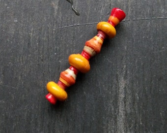 A Single, Turned look, Stripe paint, Tube bead, A Rustic, Boho Spindle drop bead in Yellow, red, brown and grey