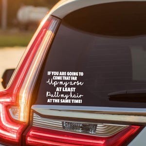 May include: White vinyl car sticker with the text "IF YOU ARE GOING TO COME THAT FAR Up my arse AT LEAST Pull my hair AT THE SAME TIME!". The sticker is applied to a car window.