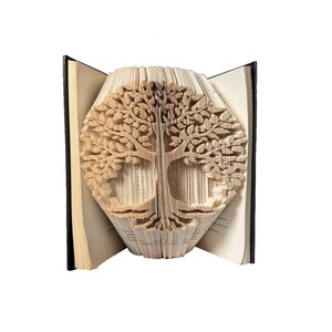 May include: A book art sculpture of a tree, created by folding the pages of a book. The tree is made of paper and has a brown colour.