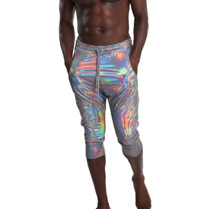 Puede incluir: Un hombre con pantalones plateados iridiscentes con cintura de cord&oacute;n. Los pantalones son cortos y tienen un ligero brillo.