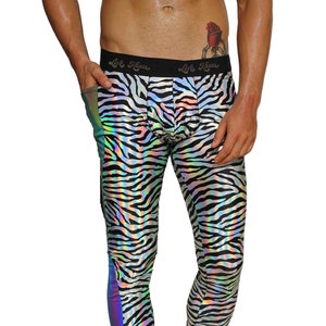 May include: Black and white zebra print leggings with a iridescent rainbow stripe down the side. The leggings are made of a shiny, stretchy material. The model is wearing black boots.