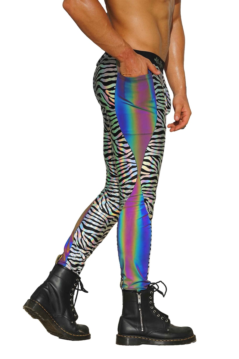 May include: Black and white zebra print leggings with a iridescent rainbow panel on the side. The leggings have a zipper detail on the side.