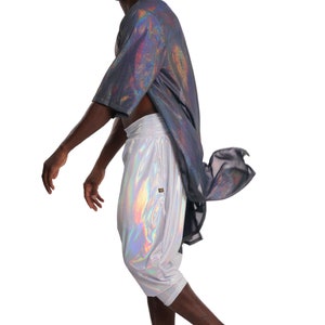 K&ouml;nnte beinhalten: Eine Person tr&auml;gt ein silberfarbenes, irisierendes Hemd und eine Hose. Das Hemd ist locker geschnitten und hat ein langes, flie&szlig;endes Design. Die Hose ist kurz und hat einen Kordelzug.