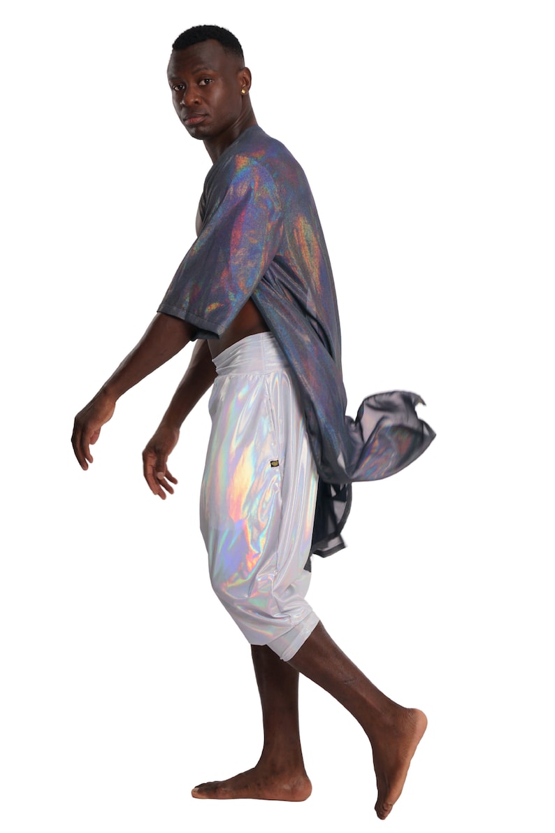K&ouml;nnte beinhalten: Eine Person tr&auml;gt ein silberfarbenes, irisierendes Hemd und eine Hose. Das Hemd ist locker geschnitten und hat ein langes, flie&szlig;endes Design. Die Hose ist kurz und hat einen Kordelzug.