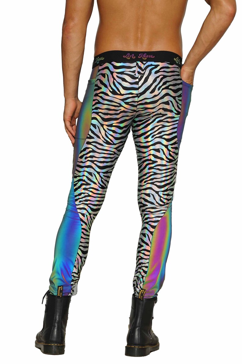 May include: Black and white zebra print leggings with iridescent rainbow panels on the sides. The leggings have a black waistband with the text "Love. Chaos" printed on it.