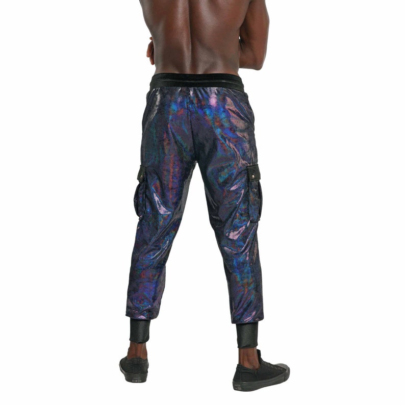 May include: Black cargo pants with a iridescent sheen. The pants have a black waistband and two cargo pockets on the sides.