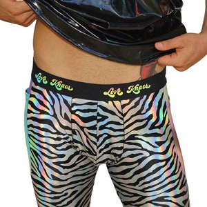 May include: Black and white zebra print leggings with a rainbow iridescent sheen. The leggings have a black waistband with the text "Love Khaos" in rainbow lettering.
