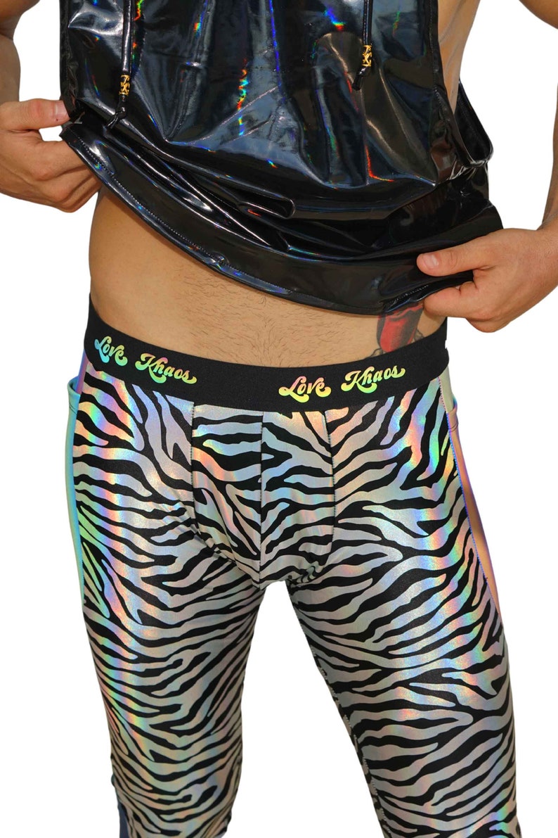 May include: Black and white zebra print leggings with a rainbow iridescent sheen. The leggings have a black waistband with the text "Love Khaos" in rainbow lettering.